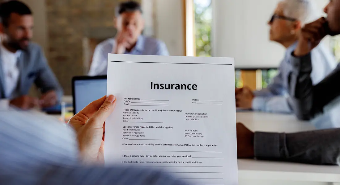 Person holding insurance document at meeting