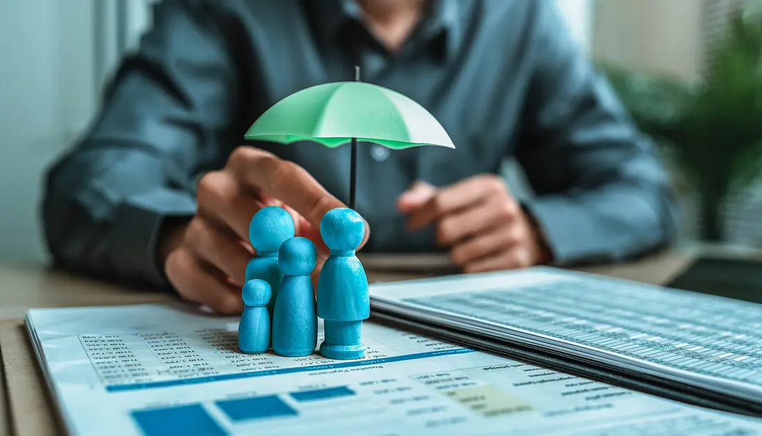 Miniature family under umbrella on financial documents