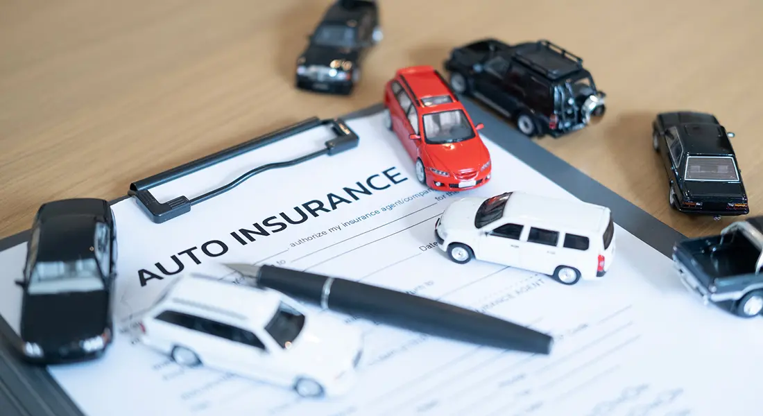 Pen and cars on insurance paper