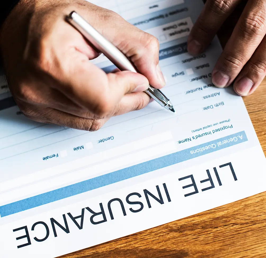 Hands signing life insurance document