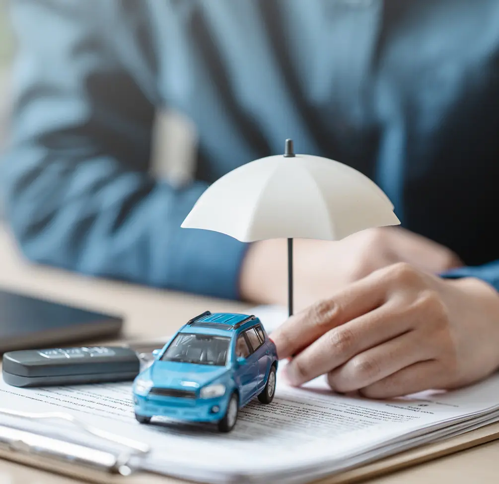 Hand holding umbrella over blue car