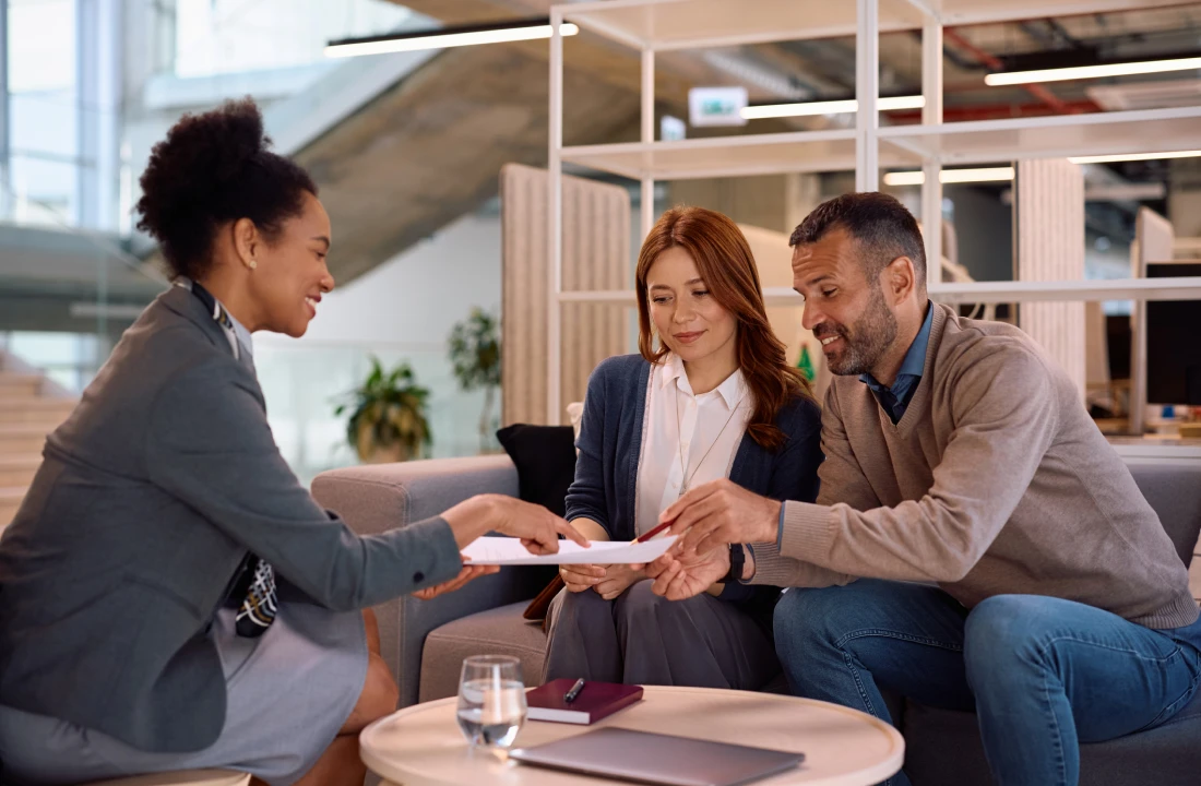Professionals reviewing paperwork in an office setting.